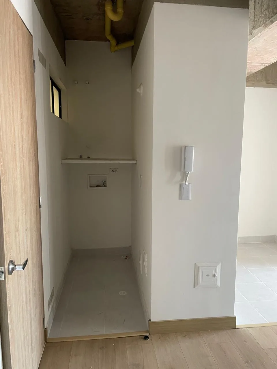 Zona de ropas independiente del apartamento, con mesón y conexiones para lavadora.