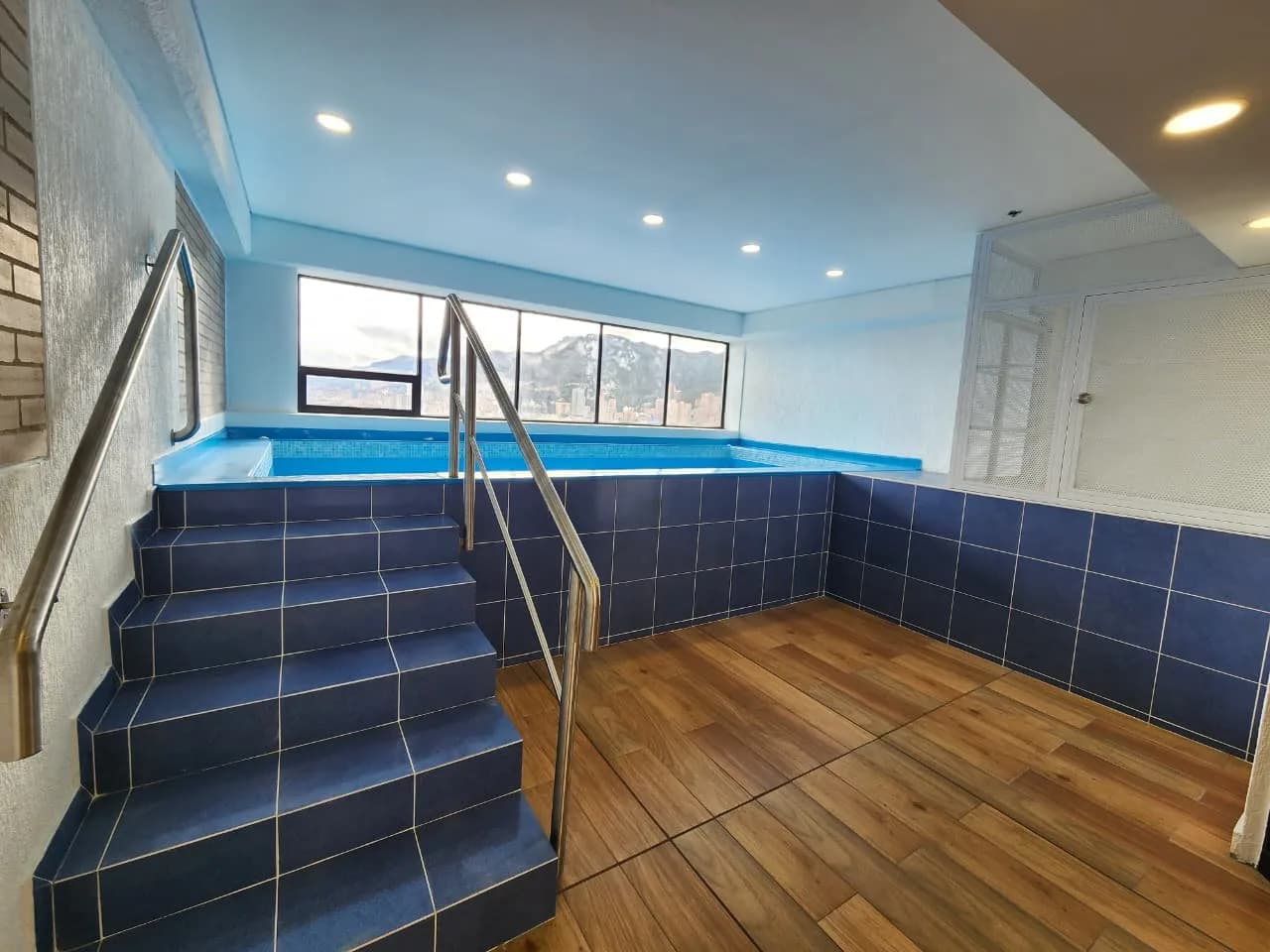 Zona húmeda del edificio con jacuzzi y un ventanal que da a los cerros orientales.
